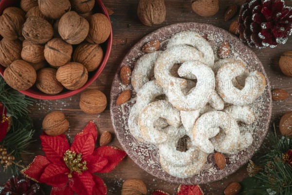 Vanilla croissants on a plate next to walnuts and Christmas decoration