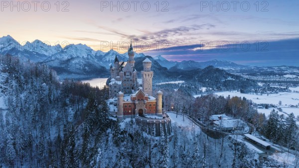 Neuschwanstein Castle at sunset with snowy mountains, Schwangau near Füssen, Ostallgäu, Allgäu,