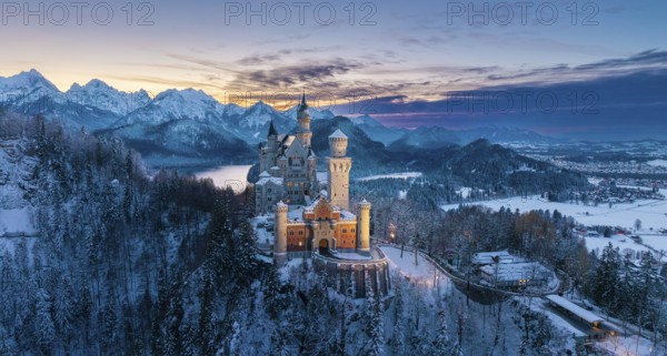 Neuschwanstein Castle at dusk in winter with mountain scenery, Schwangau near Füssen, Ostallgäu,