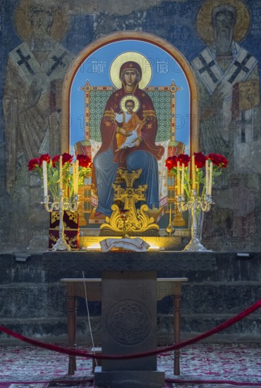 Icon of the Mother of God and Child Jesus surrounded by candles and flowers on an altar, Akhtala