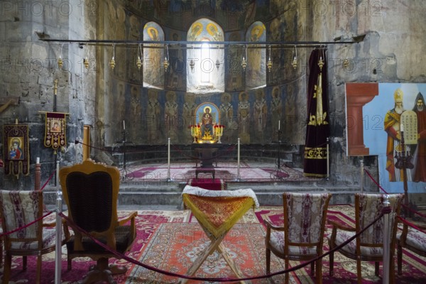 Church room with altar and religious icons decorated with carpets and candles, Akhtala monastery,