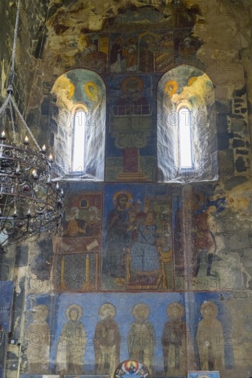 Historical wall paintings under windows in a bright church interior, Akhtala monastery, Akhtala
