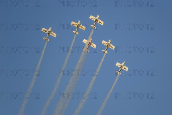 Stunt aerobatic planes performing stunts in blue sky with smoke trail. Concept of teamwork,