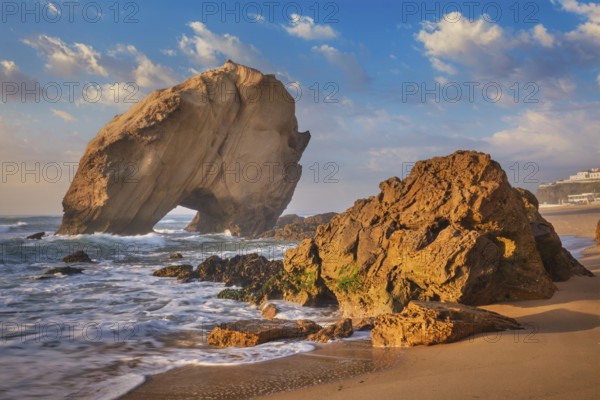 Penedo do Guincho, a large boulder rock arch at Praia da Santa Cruz, Portugal, with ocean waves and