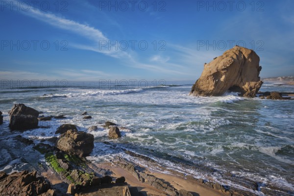 Penedo do Guincho, a large boulder rock arch at Praia da Santa Cruz, Portugal, with ocean waves and