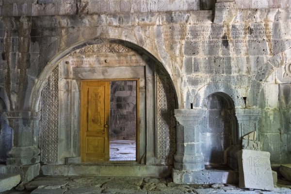 Ancient entrance with artfully carved wooden door and stone arches, Sanahin monastery, Sanahin