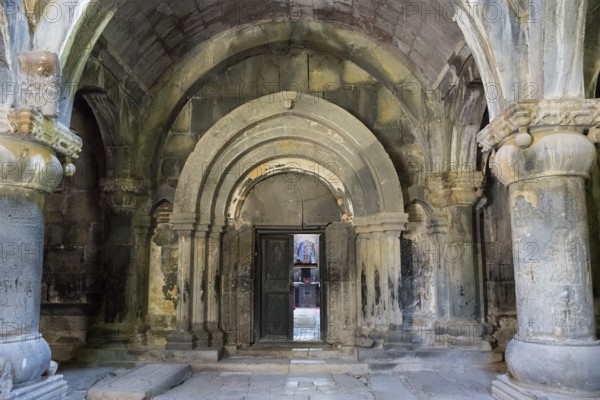 Ancient building entrance with stone arches and a central wooden door, Sanahin monastery, Sanahin