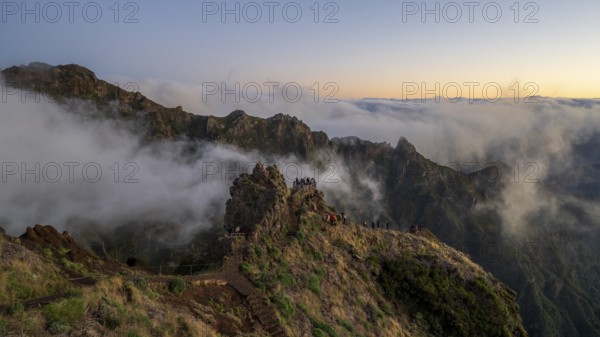 Sunrise at Pico do Arieiro, clouds of fog pass over mountain peaks, hiking trail PR1, Madeira,