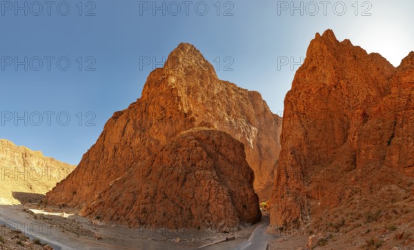 Dramatic red rocks in a sunny desert landscape with clear sky, Morocco, Todra Gorge