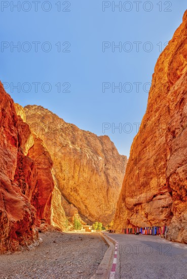 A narrow gorge with glowing red rocks under a clear blue sky, Morocco, Todra Gorge