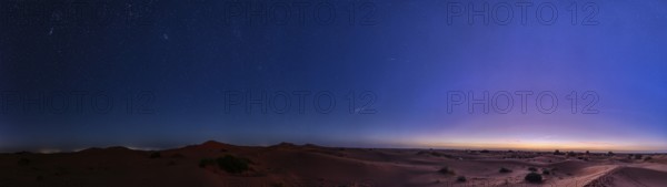 Starry sky over a desert-like landscape at dusk, Morocco, Sahara, in front of sunrise, panorama