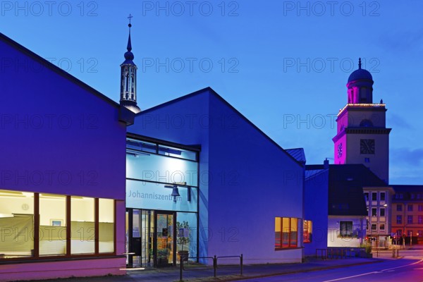 The Johanniszentrum with the top of St. John's Church and the Town Hall Tower in the evening,