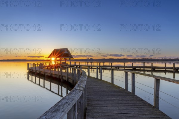 Wooden jetty on Lake Hemmelsdorf / Hemmelsdorfer See at sunrise in spring near Lübeck,