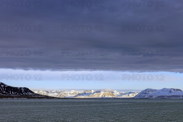 Snow covered mountains and glaciers debouching into Lilliehöökfjorden, fjord branch of Krossfjorden