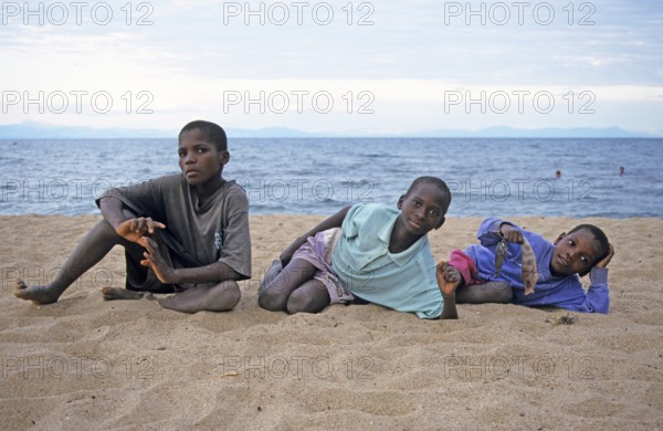 Three local boys posing for the camera on the beach, Chitimba, Lake Malawi, Africa, July 2000,
