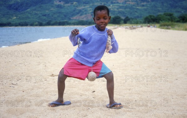 Little boy posing with caught fish for camera, Chitimba, Lake Malawi, Africa, July 2000, vintage,
