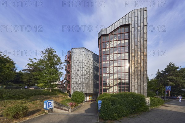 Theatre car park, modern architecture, entrance, access, sidewalk, trees, bushes, lawn, blue sky,