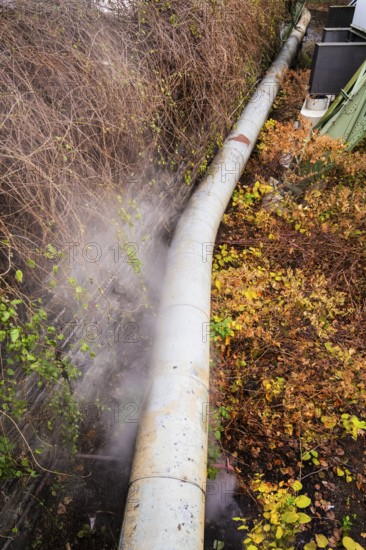 District heating pipeline in front of old industrial buildings on the banks of the Wupper,