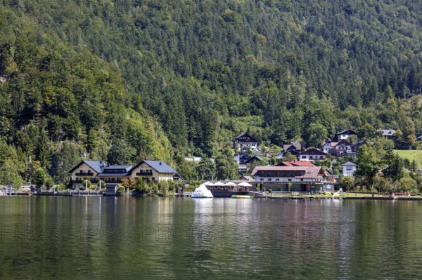 A, Hallstatt, A small lakeside village with boats and green forests in the background, Austria
