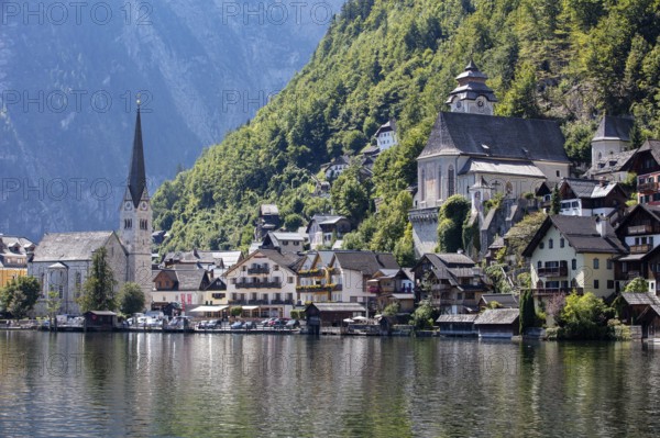 A, Hallstatt, An idyllic village with a lakeside church, surrounded by wooded mountains, Austria