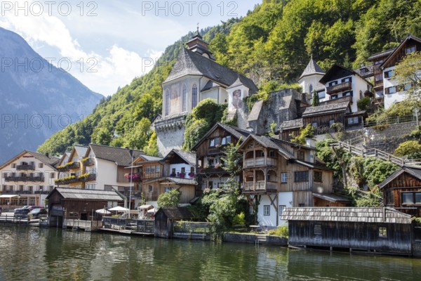 A, Hallstatt, houses on the water in front of green mountains, traditional architecture in