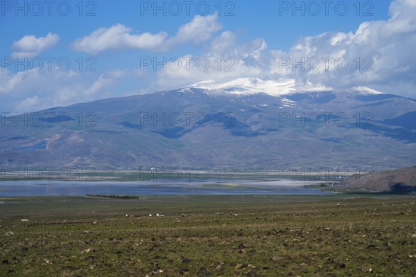 A large lake with snow-capped mountains on the horizon under blue sky, Dogubayazit swamps, wetland