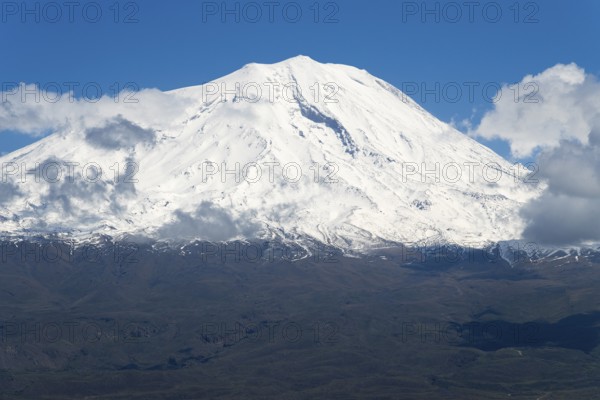 Majestic snow-covered mountain with some clouds under clear blue sky, landscape near Demirtepe,