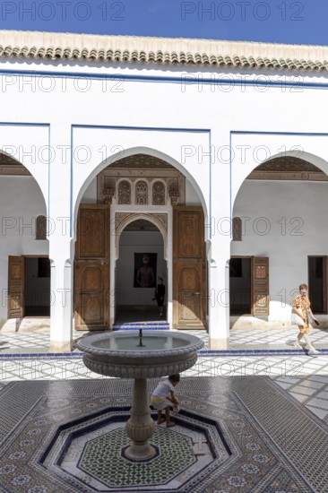 Quiet courtyard with fountain and traditional Moroccan architecture under clear skies, Bahia Palace