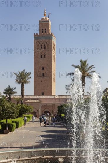 The Koutoubia Mosque in Marrakech, surrounded by palm trees and a sparkling fountain, visited by