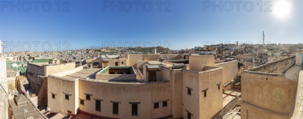 Panoramic view of the rooftops of a historic old town in strong sunlight