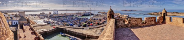 Extensive panorama of a harbor with boats and historic walls