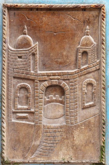 Wood carving of an architectural gate with traditional elements and two towers, traditional door