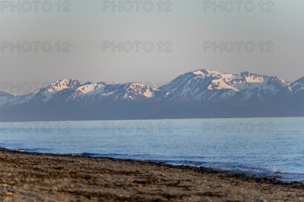 Anchor Point beach on Cook Inlet in the evening light, snowy mountain peaks of the Kenai Peninsula,
