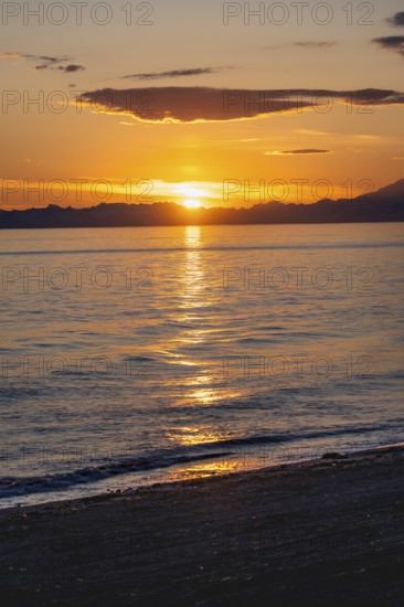 View of Cook Inlet at sunset, picturesque golden light of the midnight sun, mountains of the