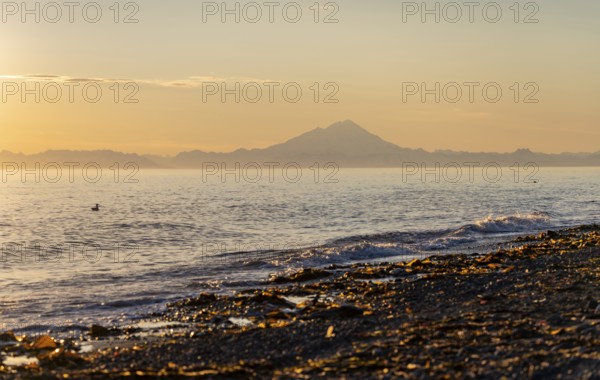 View of Cook Inlet on white mountain peaks of Mount Redoubt at sunset, midnight sun, Aleutian