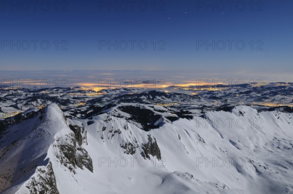 Night shot, long exposure of the 2506 meter high Säntis into the wintery, snow-covered, fog-covered