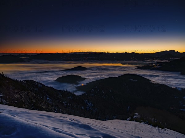 Alpine panorama at dawn in winter, fog in the valley, partly illuminated from below, Untersberg,