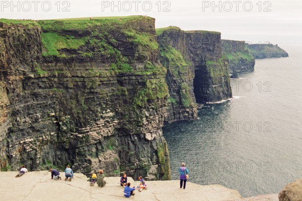 People on the cliff edge, there was no fence back then, Cliffs of Moher, County Clare, Republic of