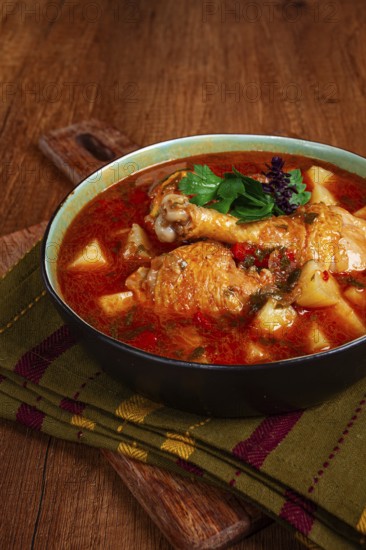 Souzi soup. Georgian dish, meat with oats, tomato sauce and herbs, on a wooden table