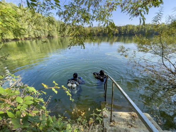 Recreational divers with diving equipment Diving tanks swim near the shore on the water surface of