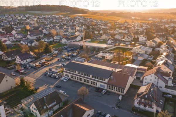 Aerial view of a village at sunset with golden autumn lights and hills in the background, Morof