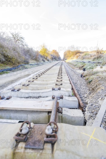 Straight tracks lead through an autumn landscape into fog, track construction of the Hermann Hesse