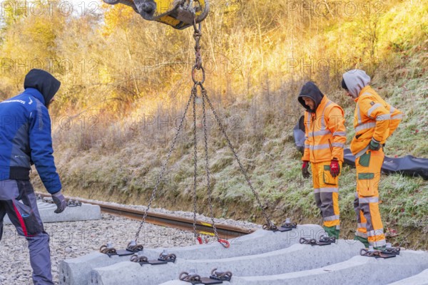 Workers lay concrete ties with an excavator under sunny autumn skies, Hermann Hesse Railway track
