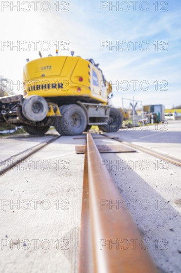 LIEBHERR excavator near rails, blue sky perspective, track preparation, Hermann Hesse Railway track