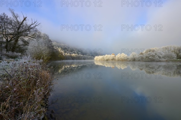 Snowy banks and fog-covered trees are reflected in the quiet lake, hoarfrost, winter, Boxtal,