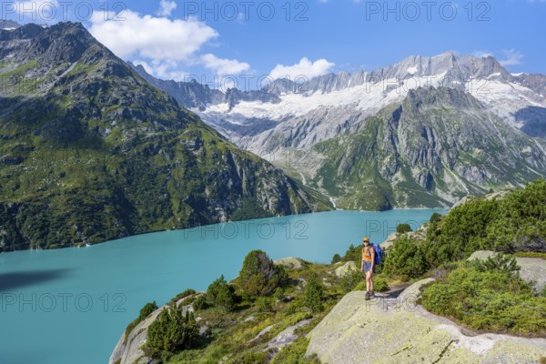 Female mountaineer in front of picturesque mountain landscape, turquoise-blue mountain lake