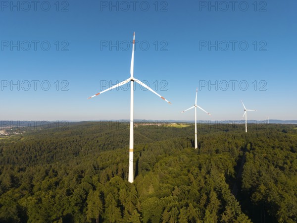 Wind turbines over dense forest stretch into the vastness of the sky, near Schorndorf, Remstal,