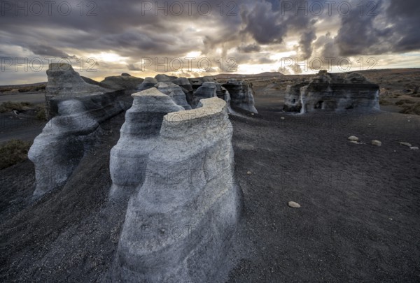 Eroded rock formations, volcanic landscape with dramatic cloudy sky at sunset, Ciudad Estratificada