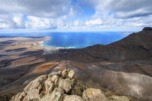 View from the Risco de Famara cliffs to the coast and the sea with the Famara beach, Playa de