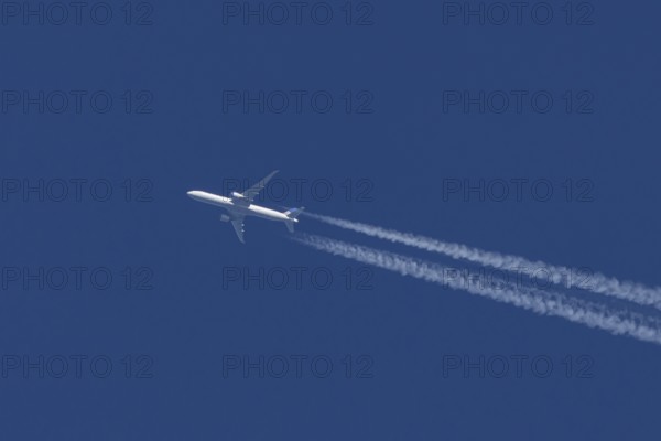 Boeing jet passenger aircraft of United airways airlines flying in a blue sky with contrails or